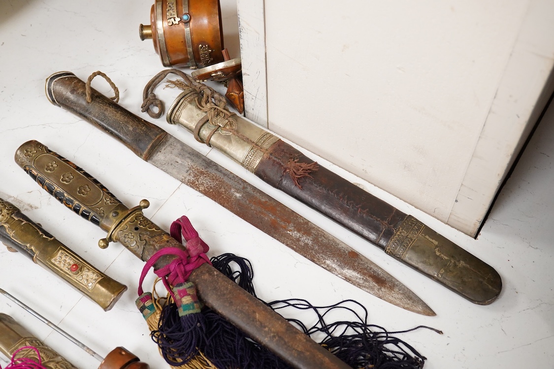 Four Tibetan daggers, early 20th century and a prayer wheel